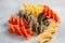 Tricolor Italian pasta on white and grey surface