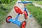 Tricycle kids bike Bicycle blue and red new is on the road in the garden to entertain children