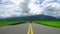 The tricycle was driving on the asphalt road. Rice fields, mountains and clouds.