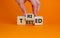 Tried and tested symbol. Businessman turns wooden cubes and changes the concept word `tried` to `tested` on a beautiful orange