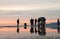 TRIESTE, ITALY - FEBRUARY, 25, 2016: Photo with reflection as a photographer takes pictures 4 fishermen at sunset with clouds, 1 m