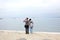 Trieste, September 5 2017, Italy: a couple of tourist taking photos standing on a stone pier