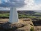 Trig point on Roseberry Topping, over Captain Cooks Monument, North York Moors