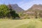 Trimmed golf course, tall trees, private houses and cottages on the mountainside, in the woods