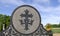 Trinity cross with crown on grave marker on a sunny day