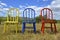 A trio of colorful Windsor wood chairs in an outdoor setting