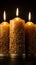 Trio of flickering candles standing alone against a black backdrop