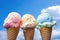 a trio of ice cream cones against blue sky