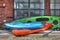 Trio of kayaks on front of brick and glass building