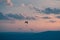 Trio of paragliders at sunset over Geneva, Switzerland.