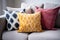 a trio of pillows in different colors on a sofa