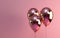 a trio of shiny balloons on a pink background,