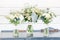 Trio of white floral arrangements in matching vases