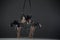 Trio of young female acrobats posing on a cube suspended at a height. Aerial gymnasts perform in studio against dark