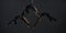 Trio of young female acrobats posing on a cube suspended at a height. Aerial gymnasts perform in studio against dark