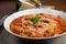 Tripe with tomato sauce called trippa alla romana, a typical dish from Lazio on wooden table