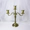 Triple bronze candelabrum with three candlesticks against background of white tulle