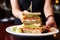 triple-decker sandwich being served by a waitress