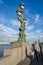 The triple lantern on the Troitskiy (Trinity) bridge and people walking along the bridge.