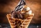 A triple scoop of chocolate, caramel, and butterscotch ice cream in a waffle cone.
