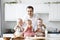 triplets, two boys and a girl in the arms of a happy father. kitchen background