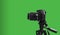 Tripod on dslr camera and isolated green background