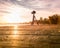 Tripod photo camera on wooden bridge films foggy bright sunrise over lake and trees