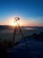 Tripod with running camera on peak ready for photography. Sharp rocky peaks