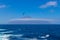 Tristan da Cunha, the most remote island, South Atlantic Ocean. Volcano covered with clouds and seagull, or gannet on foreground.