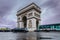 Triumphal arch. Arc de triomphe. View of Place Charles de Gaulle. Famous touristic architecture landmark in rainy day. Long expos