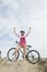 Triumphant Woman On Hilltop With Mountain Bike