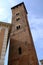 Trojan Tower of Asti. The tall tower, also known as the clock tower, is built in red terracotta bricks.  It has mullioned windows