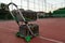 Trolley for tennis balls on the tennis court in the evening