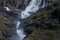 Trollstigen Road In Norway With Stone Bridge Waterfall And Dramatic Cliffs