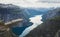 Trolltunga - famous rock formation and tourist famous hike, beautiful norwegian summer landscape with fjord, mountain and lake