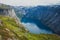Trolltunga - famous rock formation and tourist famous hike, beautiful norwegian summer landscape with fjord, mountain and lake
