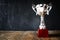 trophy over wooden table and dark background