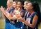 Trophy, sports and women clapping hands for success, motivation or celebration at professional netball game. Winning