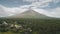Tropic countryside with palm trees aerial. Mayon volcano hillside valley. Rural cityscape cottages
