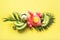Tropical banner of fruits, banana, lime, leaves palms, orange juice in inflatable pink flamingo, fresh coconut on punchy pastel