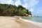 Tropical beach and bungalows on rocky hill