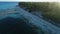 Tropical beach with coconut palms and sunrise tones. Aerial view of ocean coastline on Fuvahmulah island