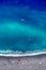 Tropical beach with colorful beach towls, people, divers and surfers - Top down aerial view