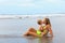 On tropical beach funny baby boy kiss young beautiful mother