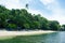 Tropical beach with green trees and white sand. Exotic island paradise toned photo.