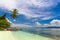 Tropical beach with local boats, coconut palm, white sand and turquoise water