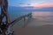 Tropical beach with old wood snag at sunset