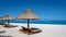 Tropical beach with palm trees and white sand blue ocean and beach beds with umbrella,Sun chairs and parasol under a