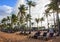 Tropical beach resort and villa with deckchairs, white sand and palm trees