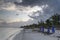 Tropical beach in sunrise with overcast, sun beds and blue sun shades